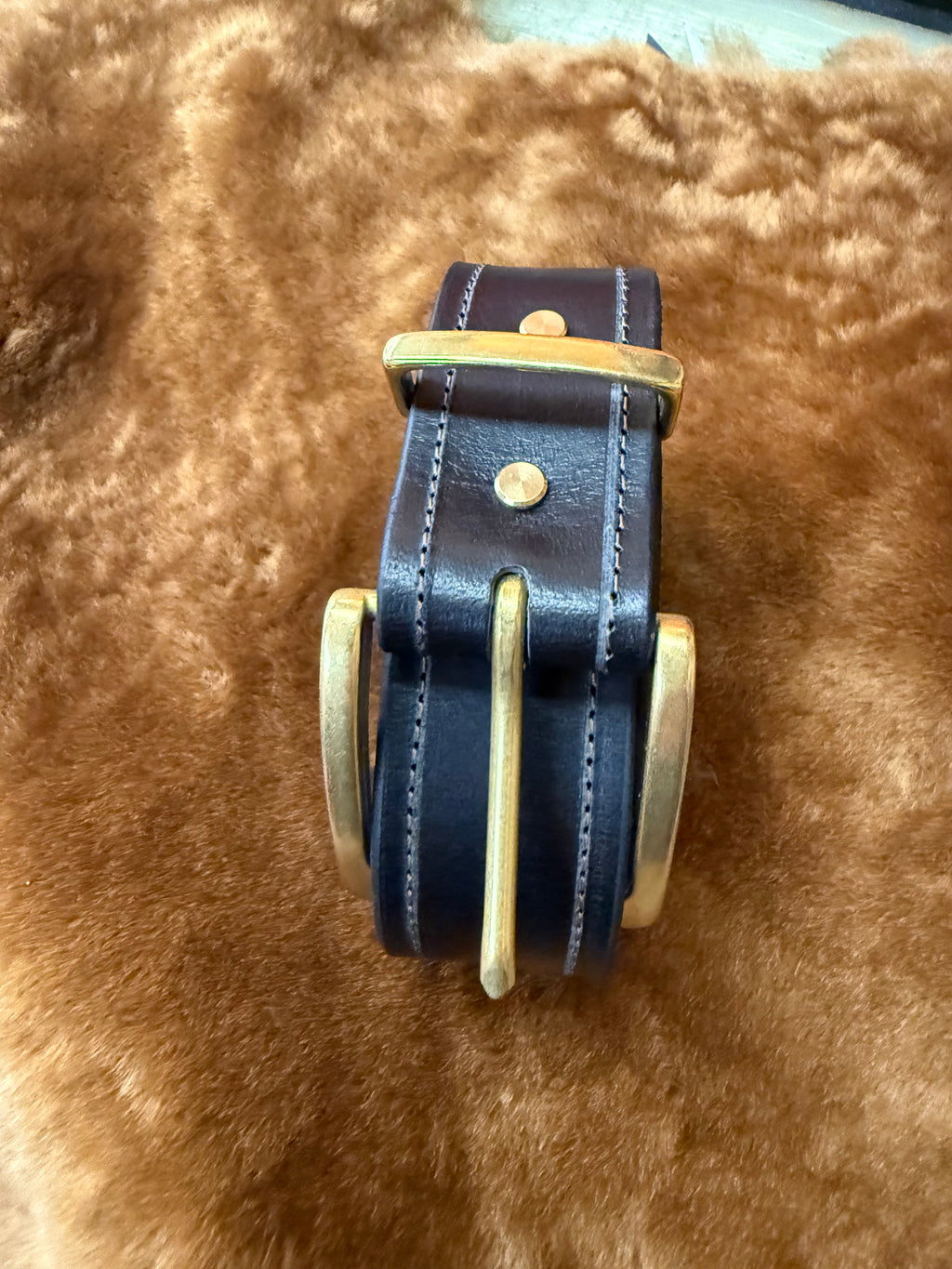 Premium leather belts for everyday use displayed on a soft brown background, showcasing its high-quality craftsmanship.