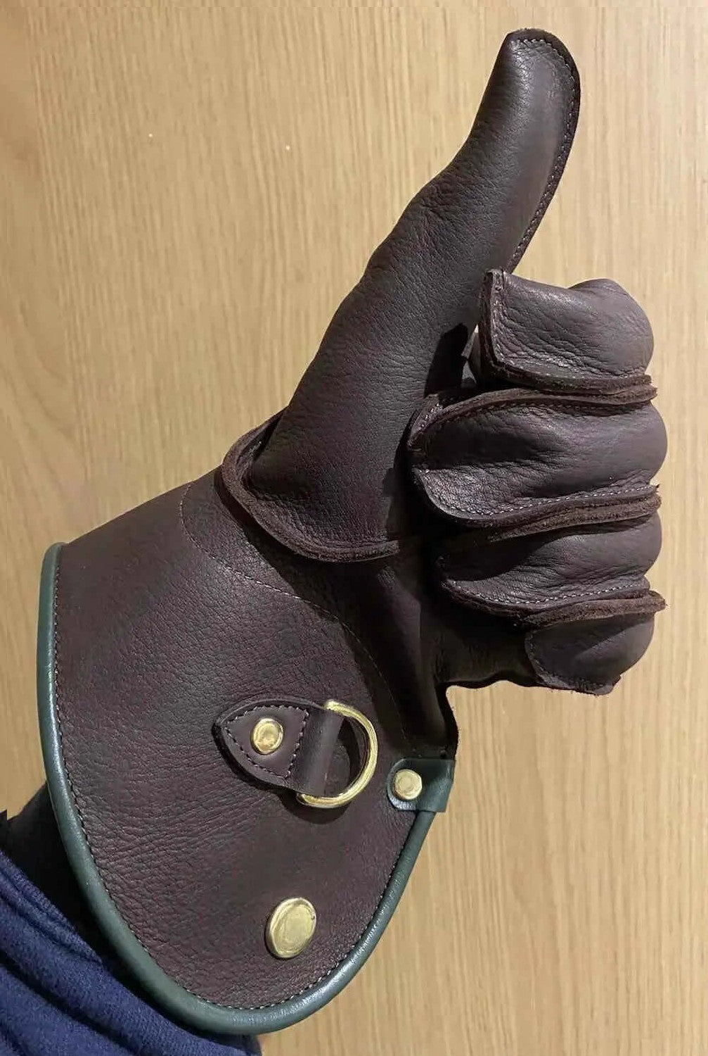 Close-up of a hand wearing machine sewn falconry gloves, showcasing premium leather and durable design.