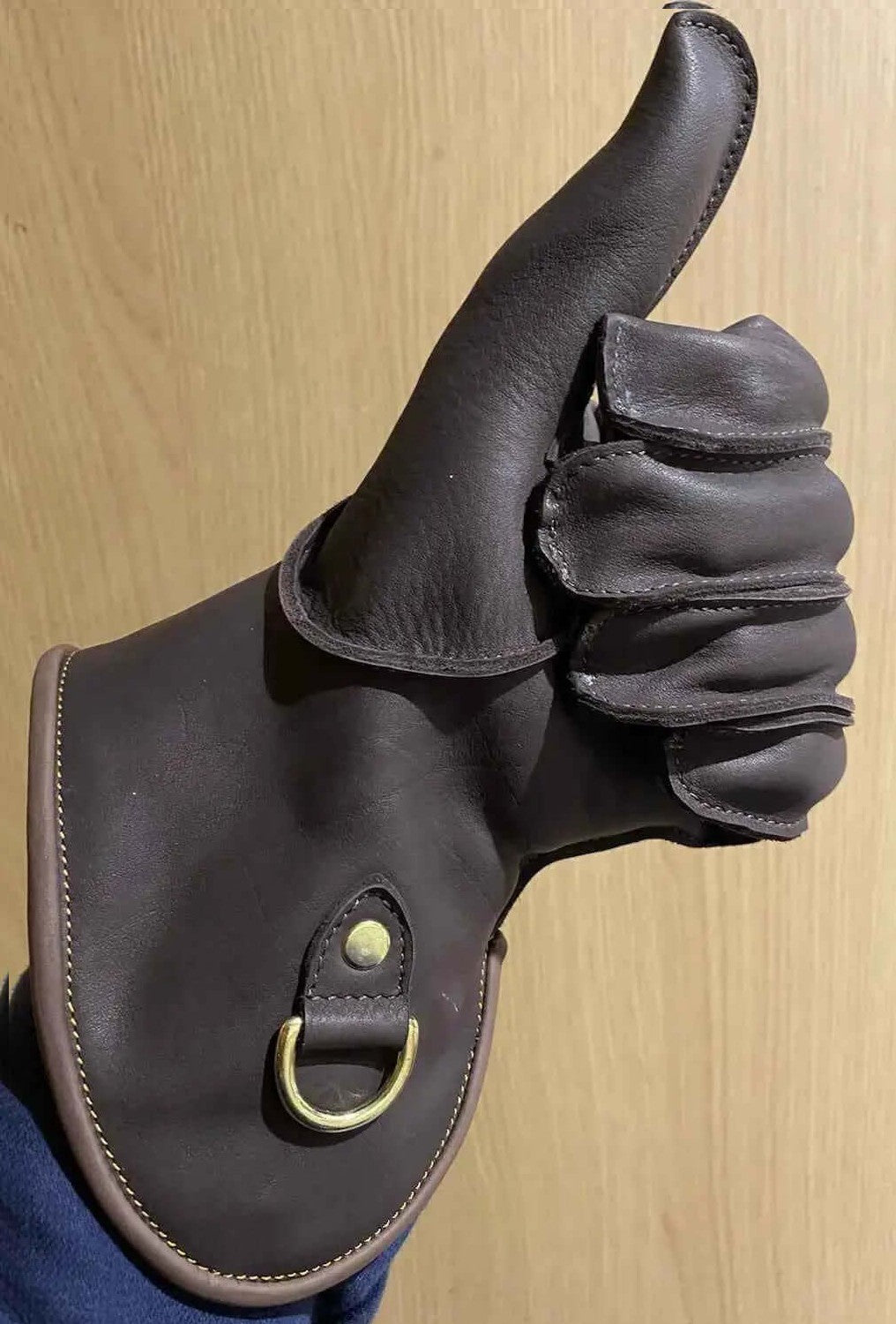 Machine sewn falconry gloves with a thumbs-up gesture showing quality and craftsmanship.