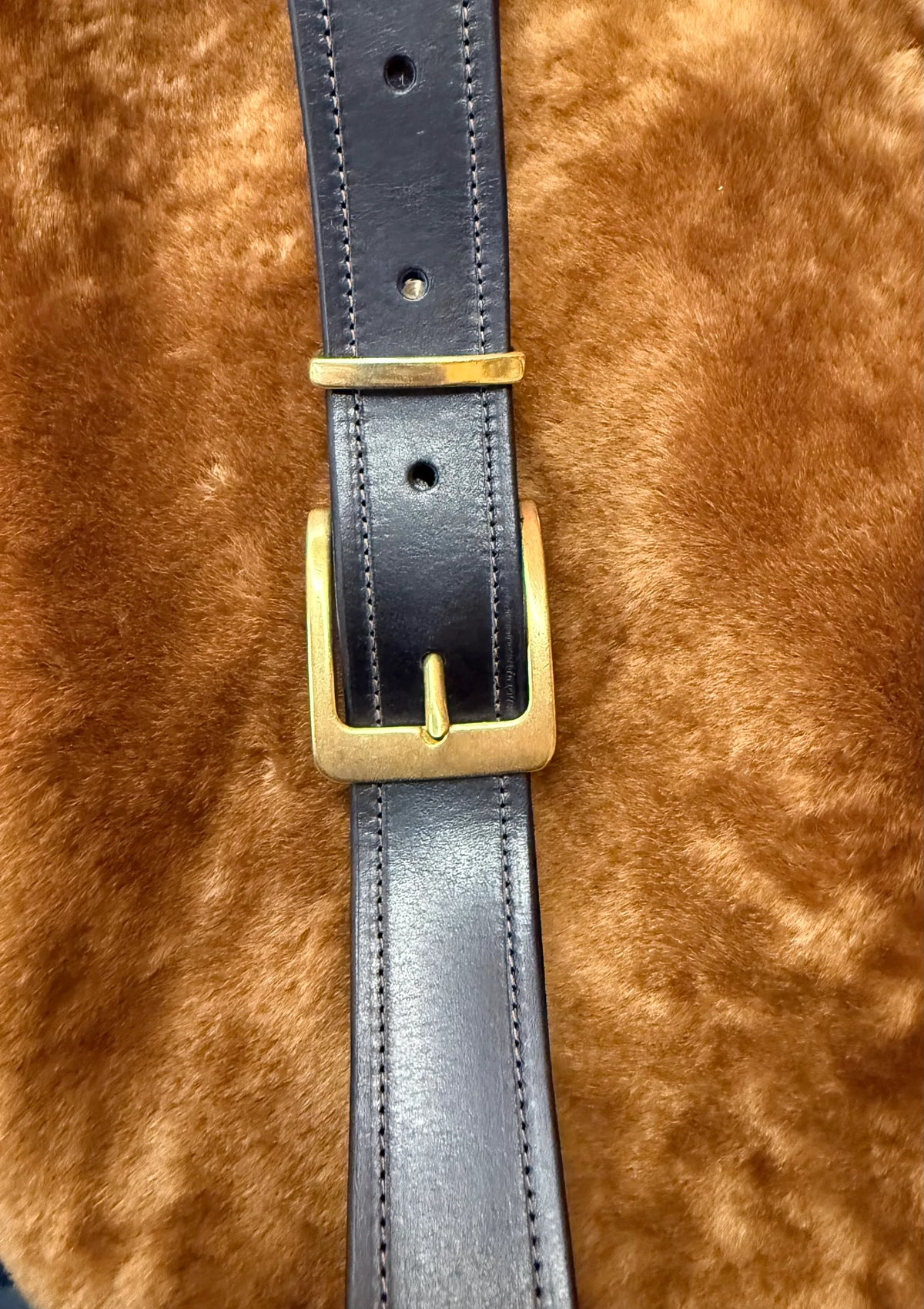 Close-up of premium leather belts for everyday use featuring a gold buckle on a soft background.