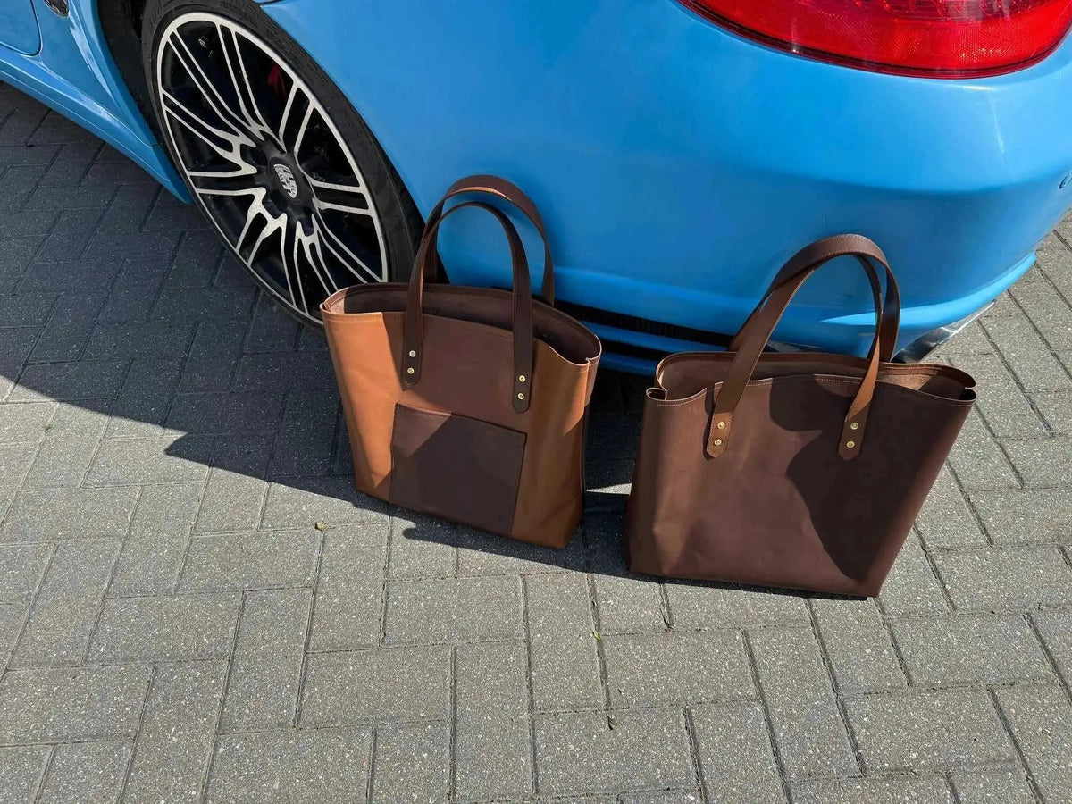 Tan and dark brown leather tote bags displayed outdoors near car