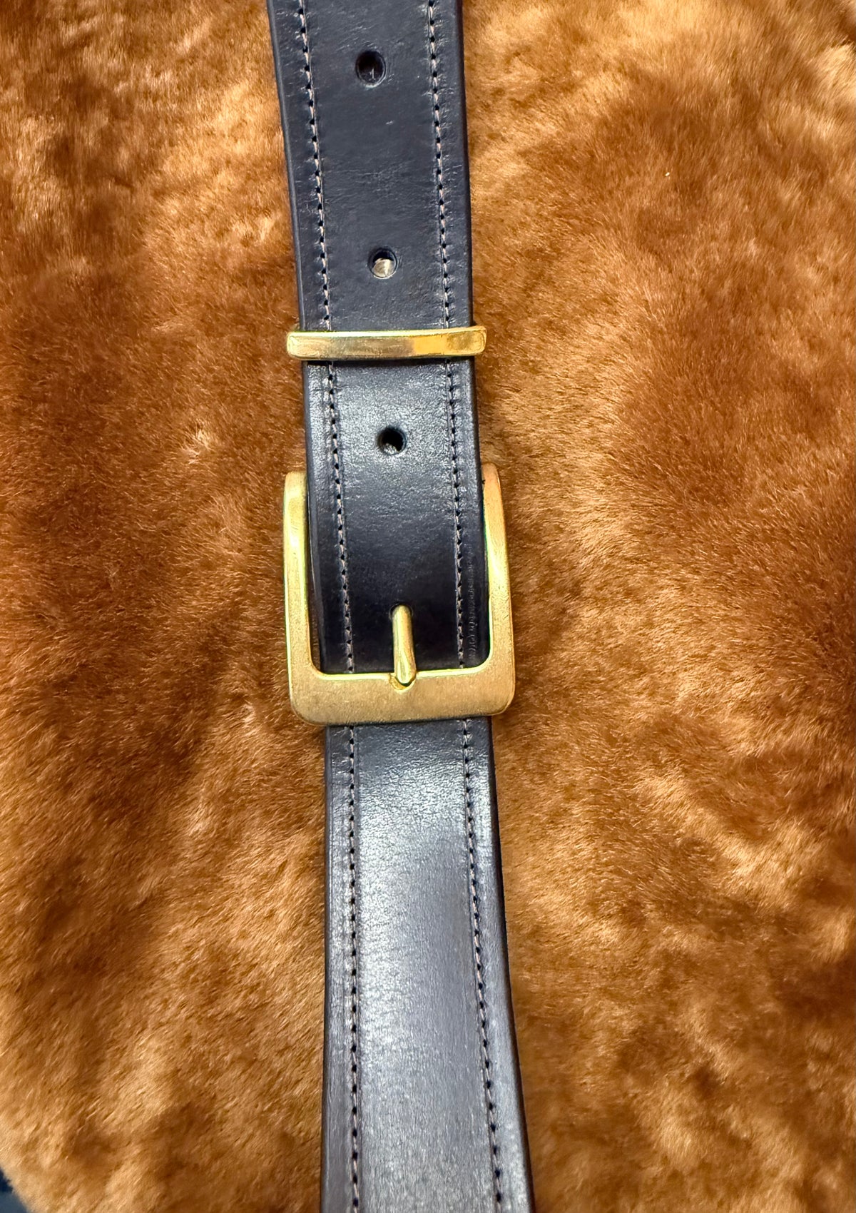 Close-up of premium leather belts for everyday use featuring a gold buckle on a soft background.