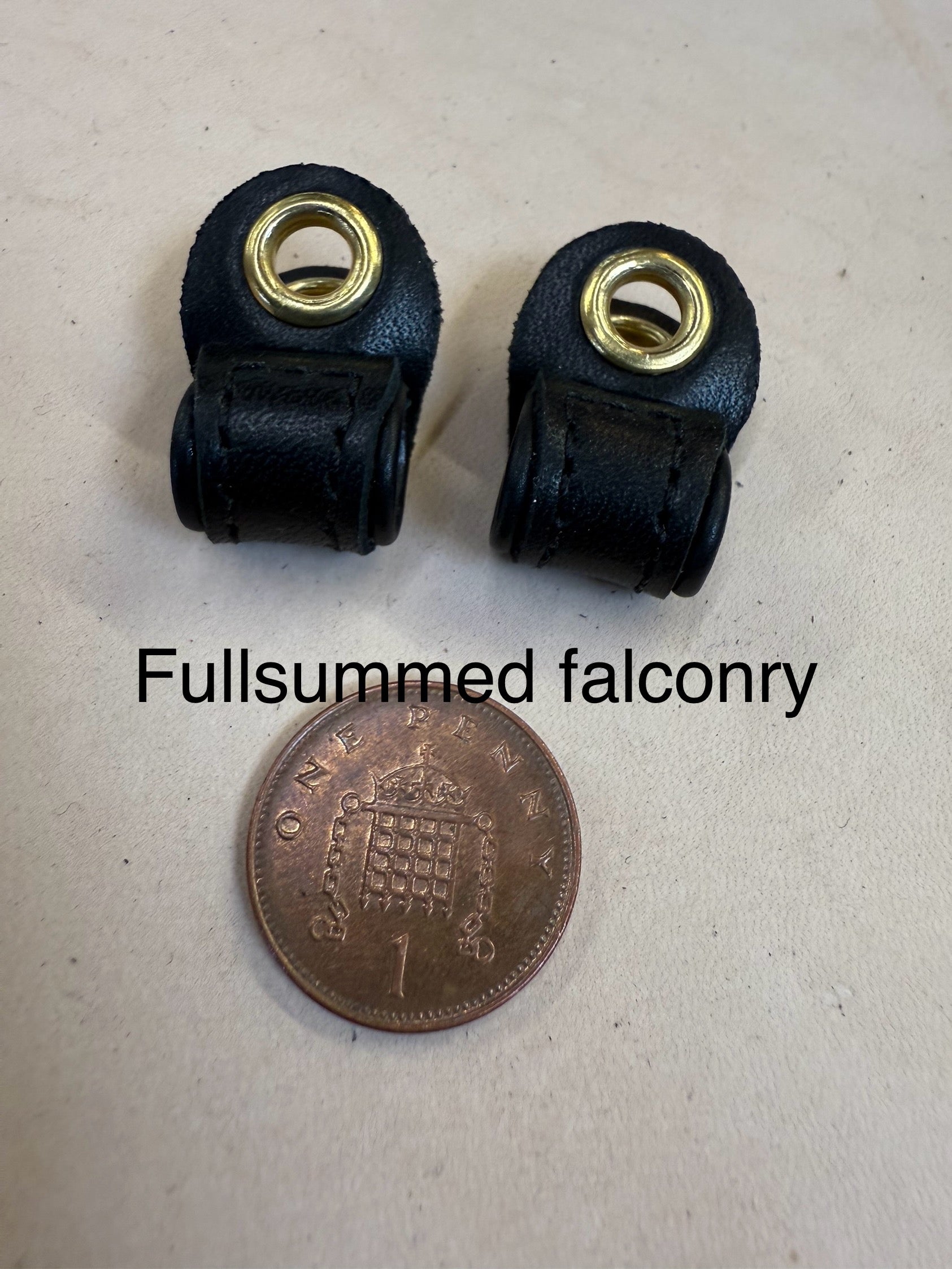 Micro false aylmeri anklets featuring rolled edges and high-quality leather, displayed with a coin for size reference.